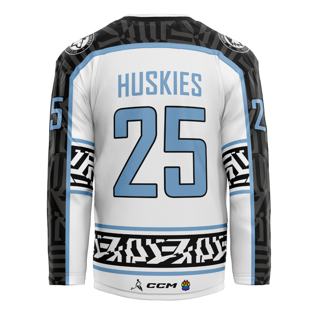 The Haringey Huskies 25/26 Home Jersey (NO NAME) from Haringey Huskies Store features a white base with black and light blue geometric sleeve and waist patterns, “Huskies” and 25 in blue on the back, plus CCM and paw print logos near the hem.