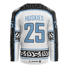 The Haringey Huskies 25/26 Home Jersey (NO NAME) from Haringey Huskies Store features a white base with black and light blue geometric sleeve and waist patterns, “Huskies” and 25 in blue on the back, plus CCM and paw print logos near the hem.