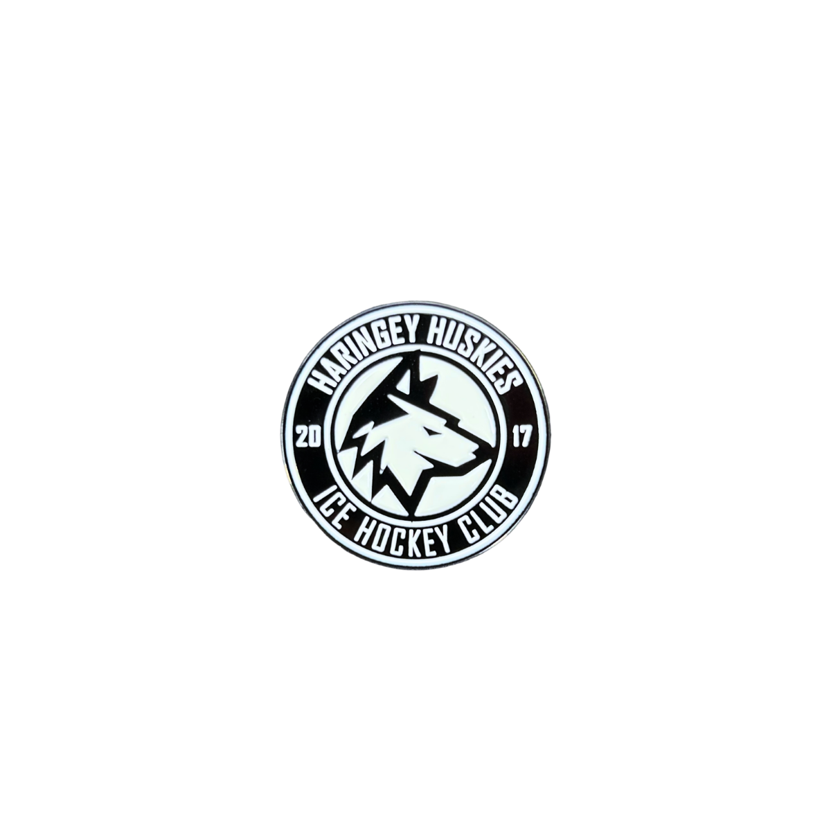 The Huskies Pin Badge from Haringey Huskies Store features a circular black and white design with a wolf head at the center, surrounded by the text “Haringey Huskies Ice Hockey Club” and “2017” split on each side.