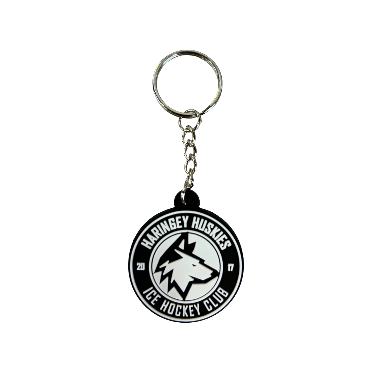 Presenting the Huskies Keyring from the Haringey Huskies Store—a round keyring showcasing the official club logo with a striking wolf head design and bold black and white text. The year 2017 appears on either side of the wolf’s head, making this keyring an ideal accessory for any dedicated Haringey Huskies Ice Hockey Club fan.