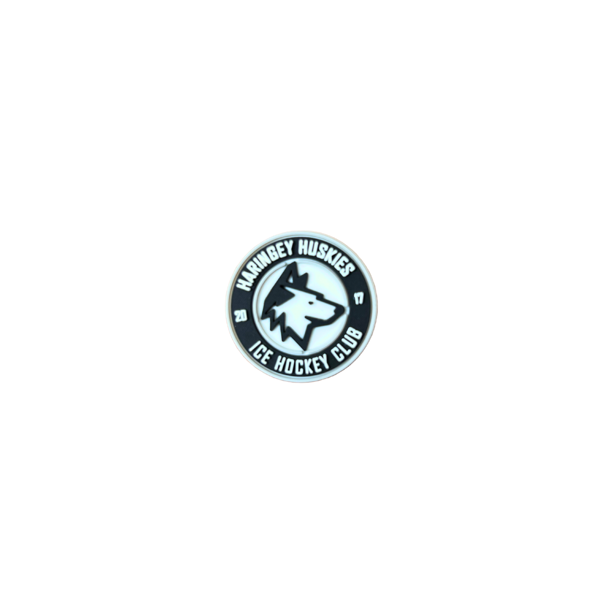 The Haringey Huskies Croc Charm from the Haringey Huskies Store features a round design with a husky head in the center and the words "Haringey Huskies Ice Hockey Club" around the edge, all in black, white, and gray.