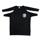 The Huskies Adult Sports T-Shirt from Haringey Huskies Store is a black short-sleeve tee featuring white stripes on the shoulders and a white circular wolf's head logo on the left chest. The shirt is displayed laid flat on a white background.