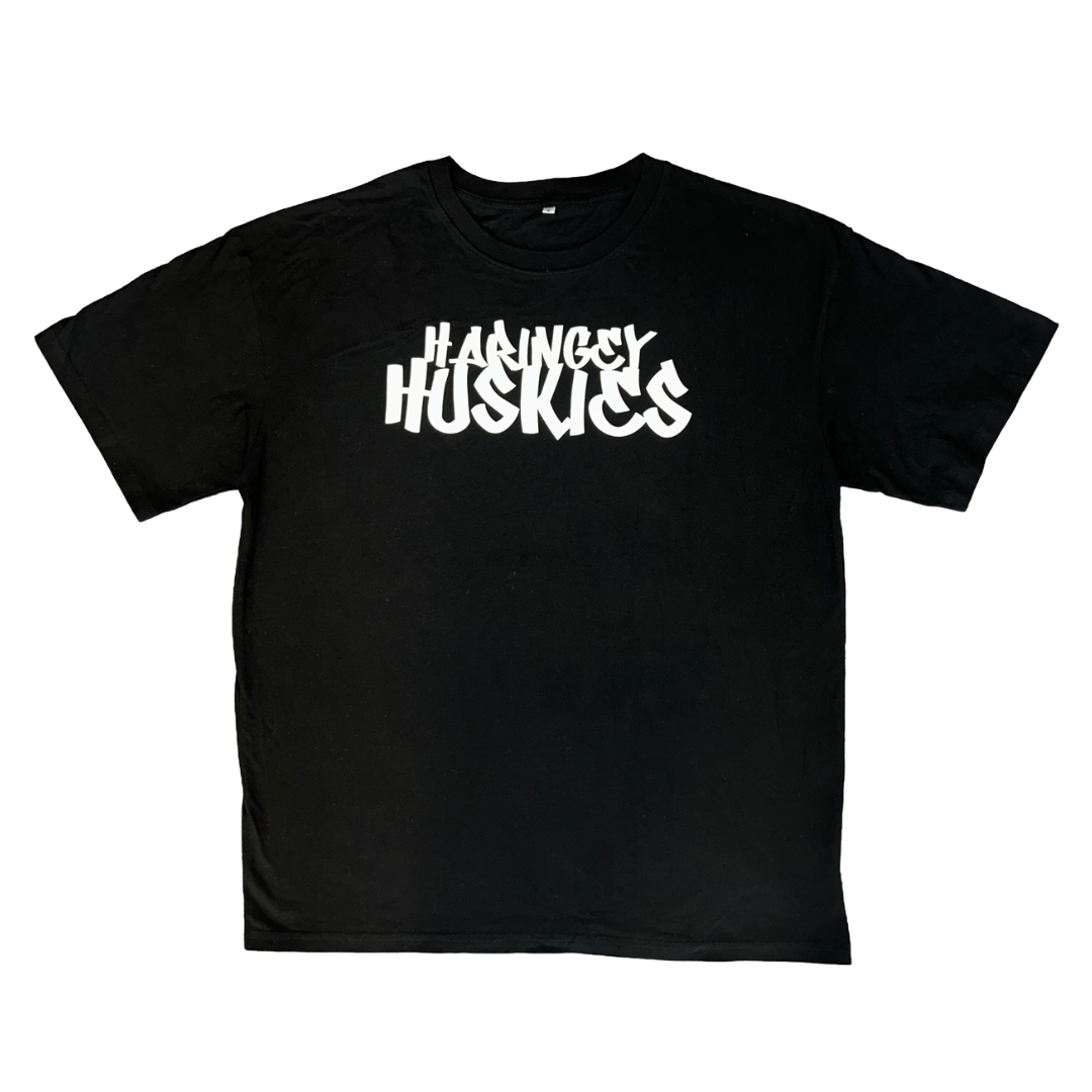 The Huskies Oversized T-Shirt Black from Haringey Huskies Store features bold, white, stylized "HARINGEY HUSKIES" text across the chest and is displayed laid flat on a white background.